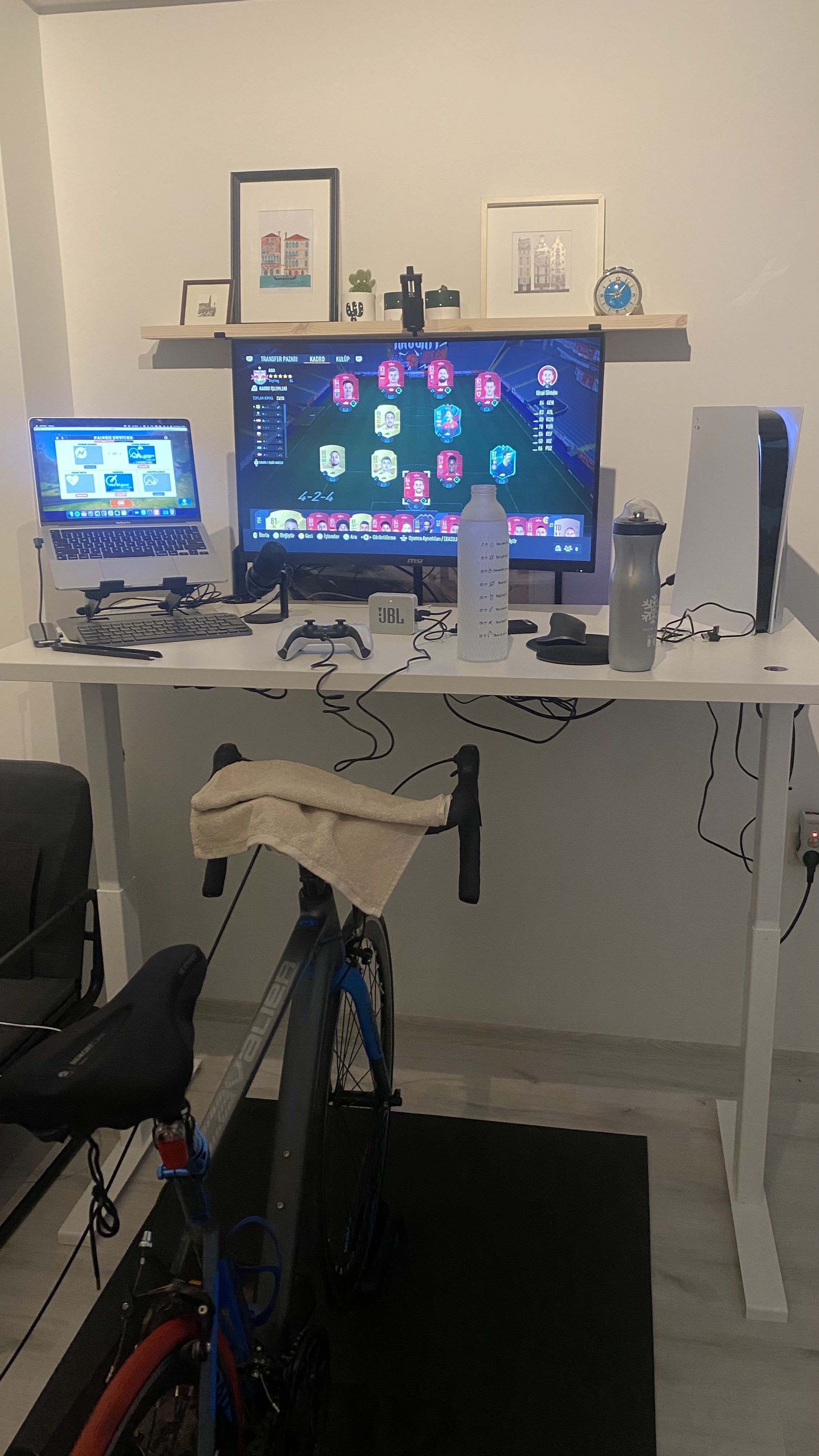 A trainer with road bike in home front of working desk