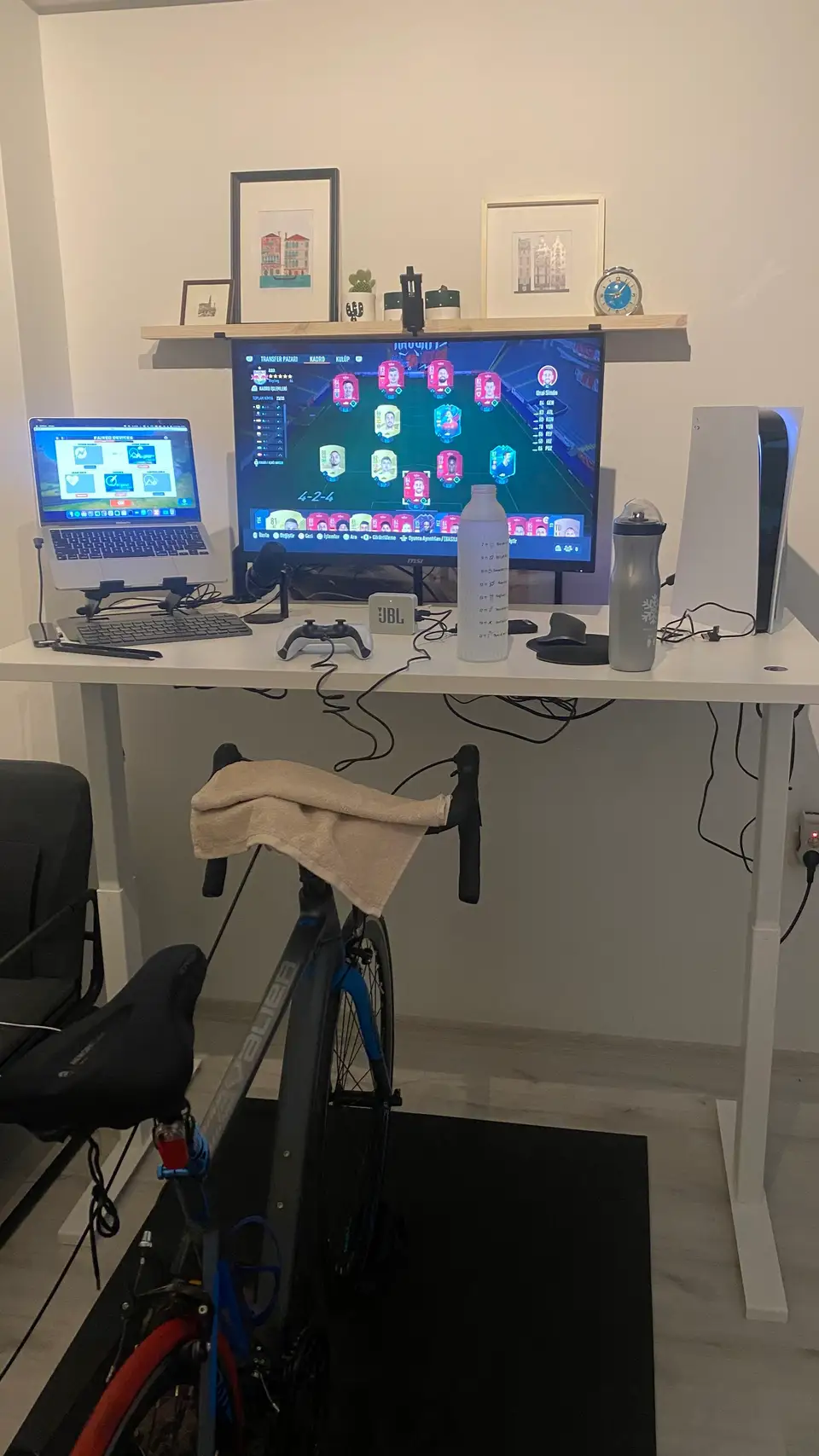 A trainer with road bike in home front of working desk