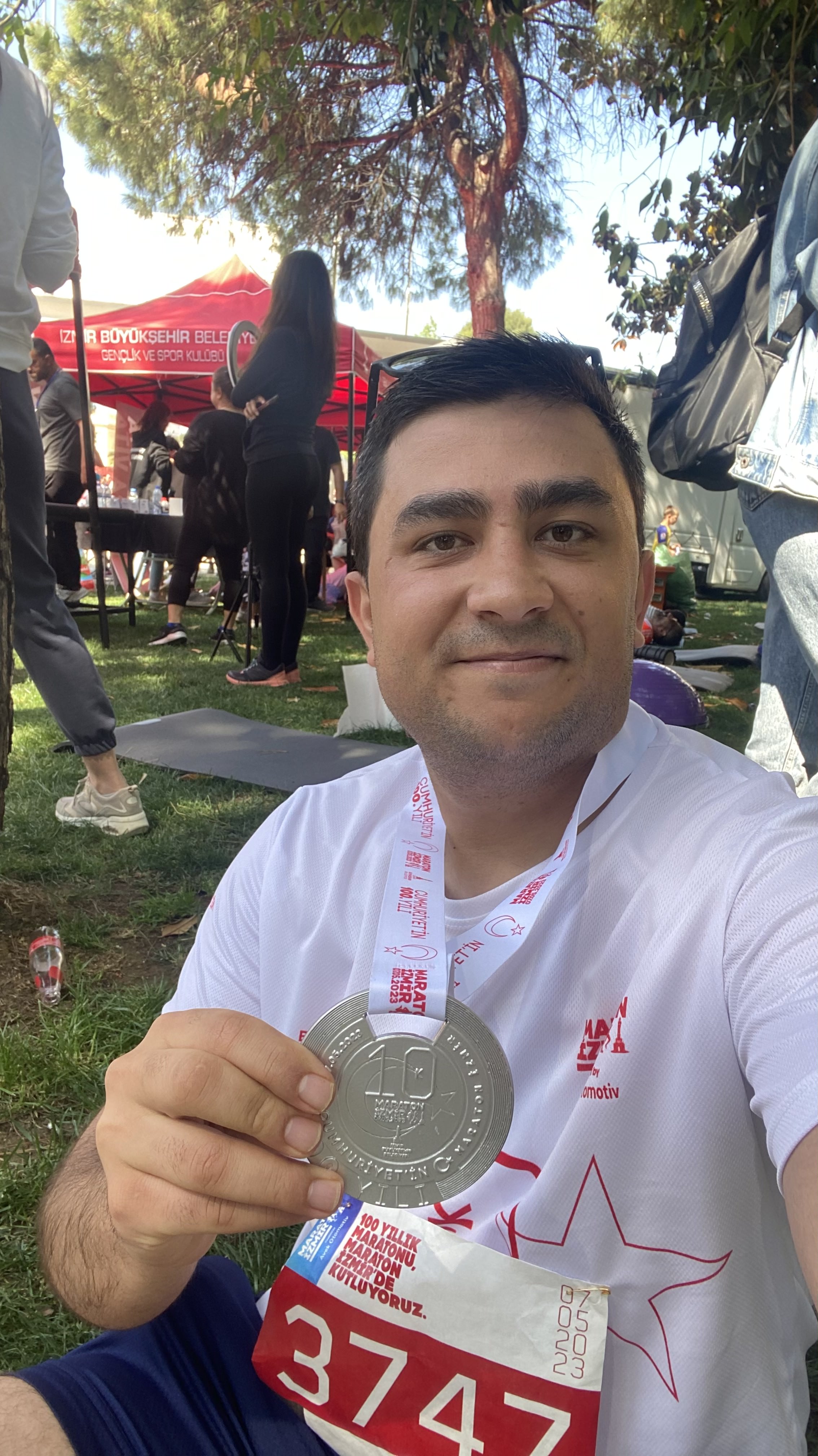 A photo of okan davut with medal that shows first 10km race