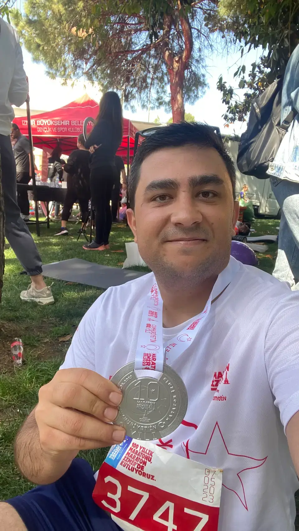 A photo of okan davut with medal that shows first 10km race